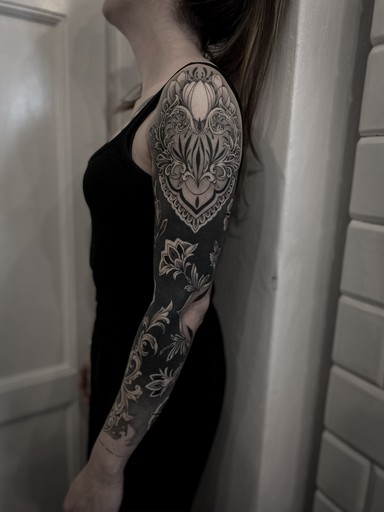 Czarno-biały, graficzny, ornamentowy tatuaż na rękawie w stylu blackwork, autorstwa Klaudii z Mongo Tattoo