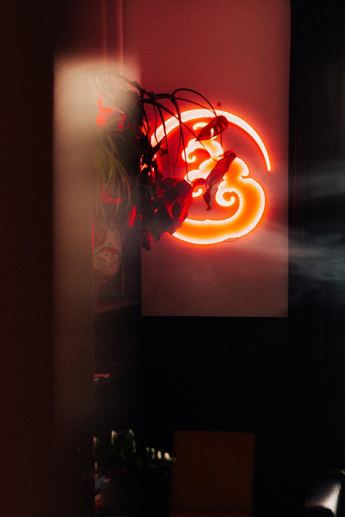 Czerwony neon przedstawiający logo studio tatuażu uroki